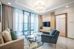 Isabelle Luxury Apartment inside Landmark 81 Tower في مدينة هوشي منه: غرفة معيشة مع أريكة وطاولة