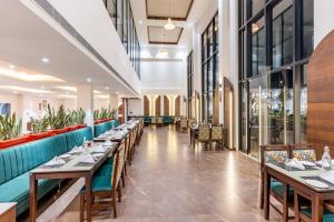 兰纳加Shervani Pebbles & Pines Resort & Spa, Corbett的有桌椅和窗户的餐厅