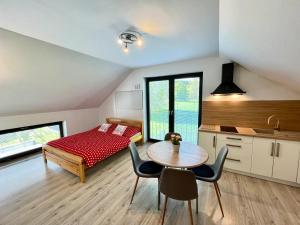 a bedroom with a bed and a table and chairs at Apartmány U Kempu in Dolní Lomná