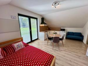 a bedroom with a bed and a table and a kitchen at Apartmány U Kempu in Dolní Lomná
