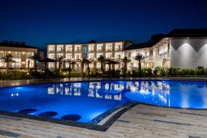 兰纳加Shervani Pebbles & Pines Resort & Spa, Corbett的夜晚建筑物前的游泳池