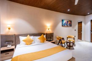 1 dormitorio con 1 cama, mesa y sillas en Shervani Pebbles And Pines Corbett, en Rāmnagar