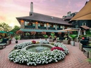 a large building with a flower garden in front of it at Fairmont Le Chateau Montebello in Montebello