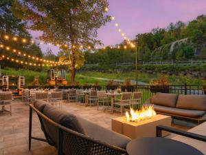 un patio con mesas, sillas y una hoguera en Fairmont Tremblant, en Mont-Tremblant