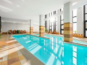 - une grande piscine d'eau bleue dans un bâtiment dans l'établissement Fairmont Tremblant, à Mont-Tremblant