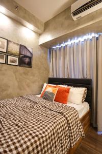 a bedroom with a bed with a checkered blanket at Kensal Industrial - Air Residences in Manila +20 photos