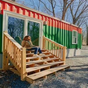 a woman sitting on the stairs of a trailer at Camptel Poconos Lodging in Albrightsville