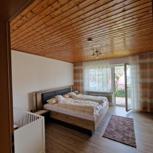 1 dormitorio con 1 cama grande y techo de madera en Ferienwohnung Mawitha en Roth