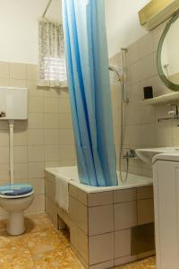 een badkamer met een toilet en een blauw douchegordijn bij Seaview Apartment Orange with sunny balcony in Kastav