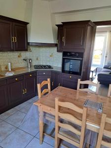 a kitchen with wooden cabinets and a wooden table at d'Artagnan in Nicole