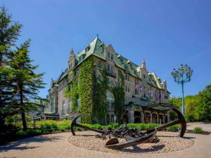 a large building with a statue in front of it at Fairmont Le Manoir Richelieu in La Malbaie