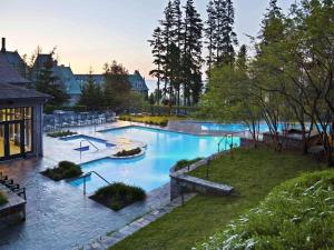 a large swimming pool in the middle of a park at Fairmont Le Manoir Richelieu in La Malbaie