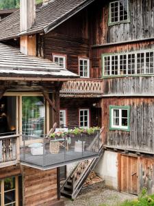una casa de madera con un balcón con flores. en Loft im Stadl, en Innervillgraten