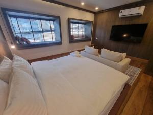 um quarto com uma grande cama branca e um sofá em The Folkster House Chiangkhan em Chiang Khan