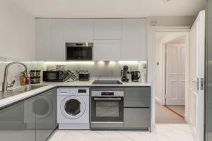 a kitchen with a washer and a sink and a dishwasher at City Chic 3 Bedroom, 3 Bathroom Luxury Living 7 in London