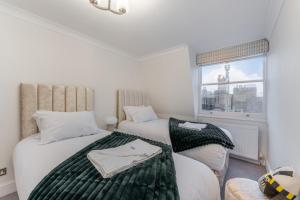 two beds in a room with a window at City Chic 3 Bedroom, 3 Bathroom Luxury Living 7 in London