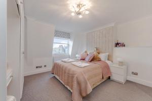 a white bedroom with a bed and a window at City Chic 3 Bedroom, 3 Bathroom Luxury Living 7 in London