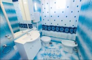 La salle de bains bleue et blanche est pourvue de toilettes et d'un lavabo. dans l'établissement Primošten-Huljev, à Primošten