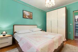 - une chambre avec un lit et un mur bleu dans l'établissement Primošten-Huljev, à Primošten