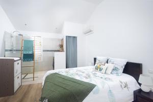 a bedroom with a large bed and a bathroom at La Villa des Lataniers in Étang-Salé +9 photos