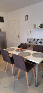 a table and chairs in a living room with a couch at Apartman Valkira in Novalja