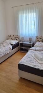 1 dormitorio con 2 camas y ventana en Apartman Valkira en Novalja