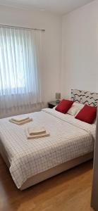 1 dormitorio con 1 cama con 2 toallas en Apartman Valkira, en Novalja