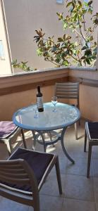 a glass table with a bottle of wine on it at Apartman Valkira in Novalja