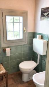 a bathroom with a white toilet and a window at 2 bedrooms apartement with enclosed garden at Carru in Carrù