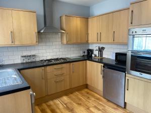 a kitchen with wooden cabinets and stainless steel appliances at Delightful home in Manchester in Manchester