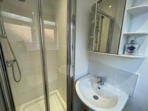 a bathroom with a shower and a sink and a mirror at Delightful home in Manchester in Manchester