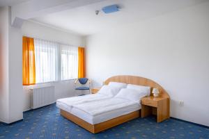 a bedroom with a bed and a chair and a window at City inn Olomouc in Olomouc