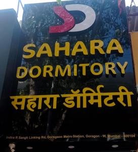 un póster para una exposición de arte de una colonia santa en Sahara Dormitory, en Bombay