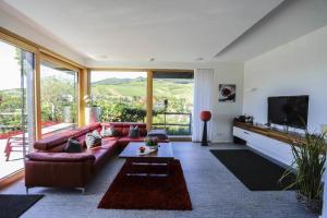 a living room with a couch and a tv at Ferienhaus mit Panoramablick in Bühlertal
