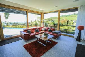 a living room with a leather couch and a table at Ferienhaus mit Panoramablick in Bühlertal