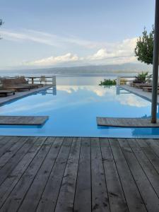 une piscine d'eau bleue et une terrasse en bois dans l'établissement The Villa Amalia, à Spartos