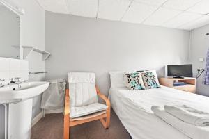 een kleine kamer met een bed en een wastafel bij Riverside Mews in Brigg