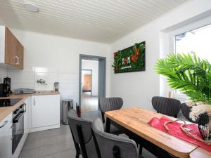 cocina y comedor con mesa y sillas en SR24 - Stillvolles gemütliches Apartment 5 in Recklinghausen, en Recklinghausen