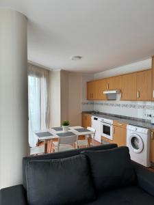 a living room with a table and chairs in a kitchen at Apartagal-Urb. Traiñeira in O Vicedo