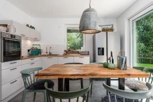uma cozinha com uma mesa de madeira e cadeiras em Kleine Binsenjungfer - Ferienhaus mit Sauna und Kamin für 6 Personen em Pepelow