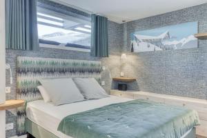 a bedroom with a bed and a large window at Chalet Ardoise in Praz-sur-Arly