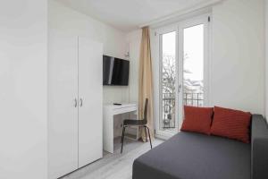 a room with a couch and a desk and a window at Cozy Urban Studio in the City BE-41 in Zürich