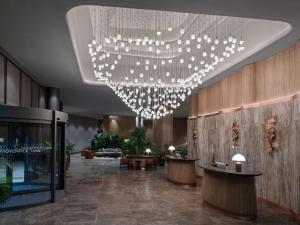 a lobby with a large chandelier in a building at Mövenpick Living Istanbul Saklivadi in Istanbul