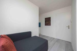 a living room with a blue couch and a white wall at Cozy Urban Studio in the City BE-41 in Zürich