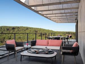 a patio with a couch and chairs on a balcony at Mövenpick Living Istanbul Saklivadi in Istanbul