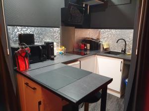 uma cozinha com uma bancada preta e uma bancada lateral. em Studio hot 