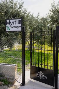 a black gate with a sign in front of it at Myrtilli Cottages Pelion in Áno Lekhónia