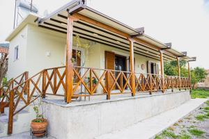 a house with a balcony with wooden railings at Myrtilli Cottages Pelion in Áno Lekhónia