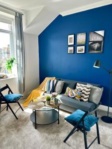 a blue living room with a couch and a table at Cosy stylish Dumbarton flat in Dumbarton