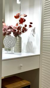 Un estante blanco con un jarrón con una planta. en Yourhome - #105 Комфорт сити, en Almaty